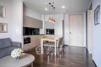 Modern open-layout kitchen and dining area with sleek design and contemporary lighting.