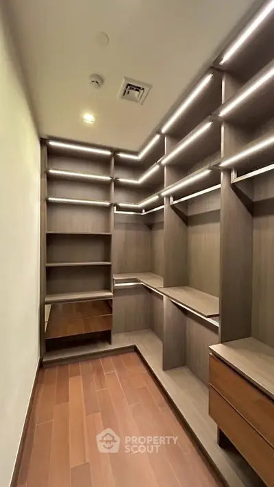 Spacious walk-in closet with modern wooden shelving and ample storage space.
