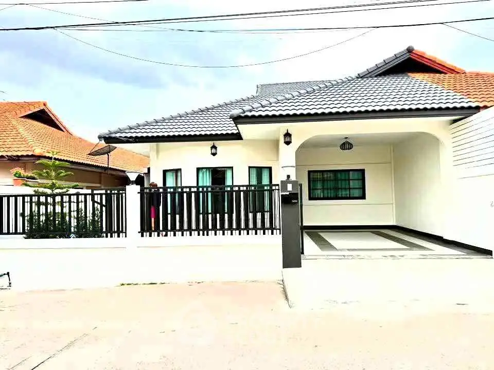 Charming single-story house with tiled roof and spacious driveway in a serene neighborhood.