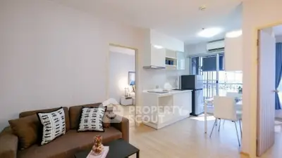 Modern open-plan living room with kitchen and dining area, featuring stylish decor and natural light.