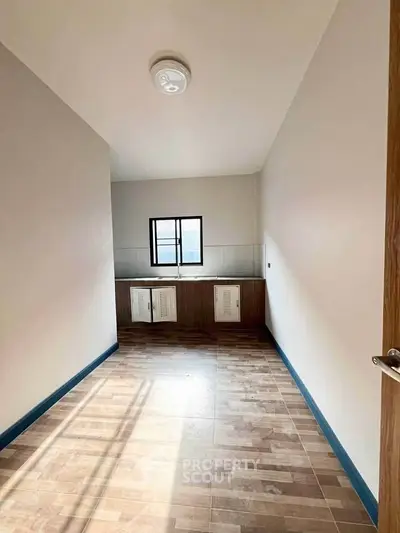 Spacious kitchen with modern tile flooring and ample natural light