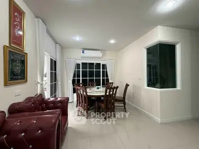 Elegant dining area with plush red seating and large windows in a modern home.