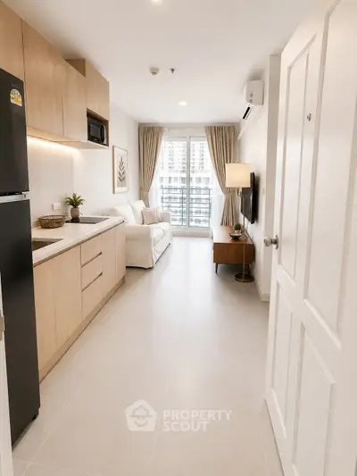 Modern open-layout kitchen and living room with natural light and stylish decor.