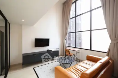 Modern living room with high ceilings, large windows, and stylish furniture in a contemporary apartment.