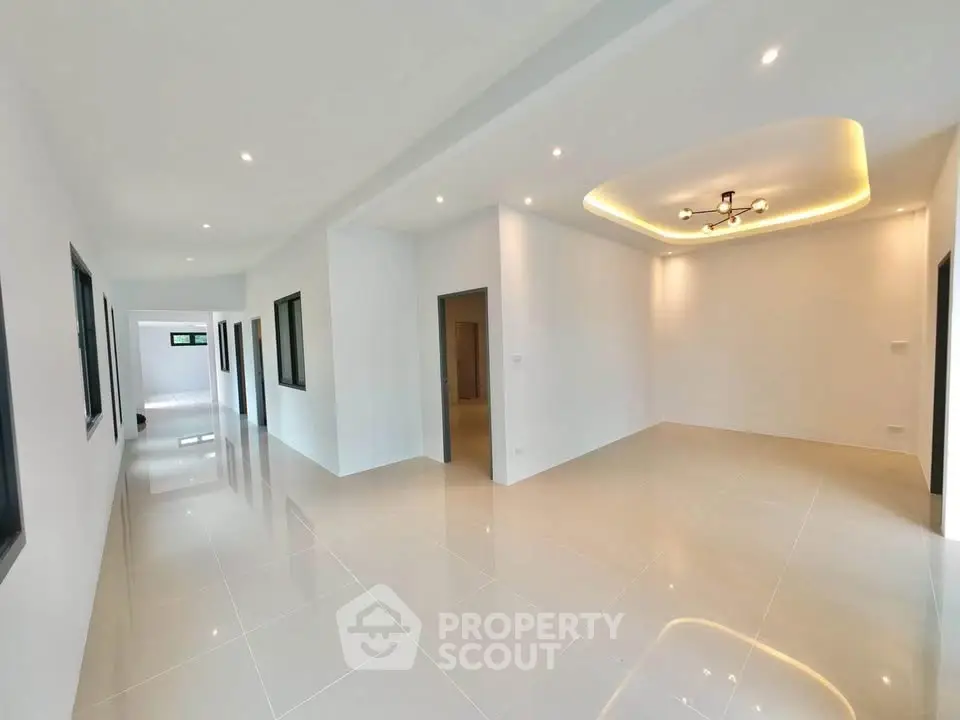 Spacious modern interior with sleek tile flooring and elegant ceiling lighting.