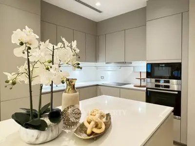 Modern kitchen with sleek cabinetry and built-in oven, featuring elegant decor and ample counter space.