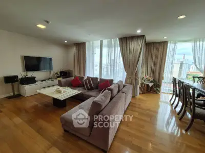 Spacious living room with city view, elegant decor, and ample natural light.