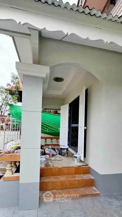 Charming exterior view of a house under renovation with fresh paint and inviting entrance.