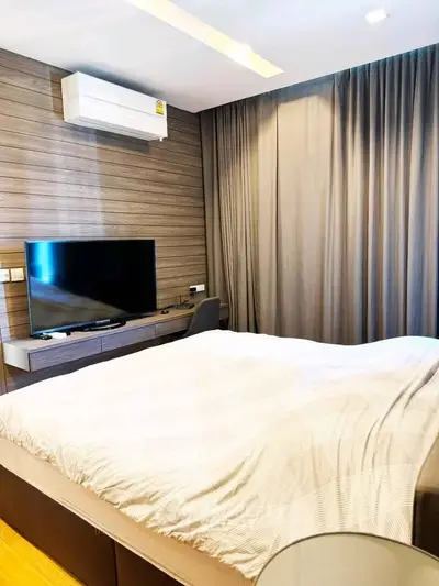 Modern bedroom with stylish decor, featuring a wall-mounted TV and air conditioning for ultimate comfort.