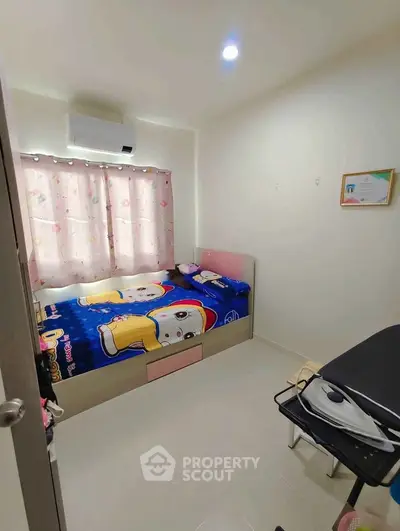 Cozy bedroom with colorful bedding and air conditioning, ideal for a comfortable living space.