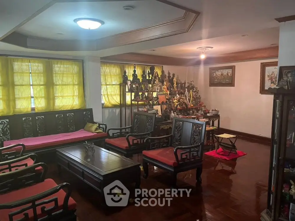 Spacious living room with traditional decor, ornate furniture, and a collection of cultural artifacts creating a unique and inviting atmosphere.