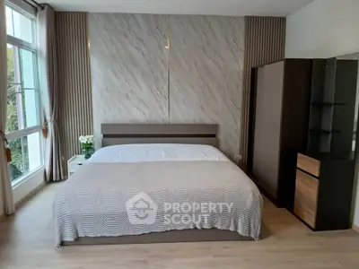 Modern bedroom with large window and stylish decor