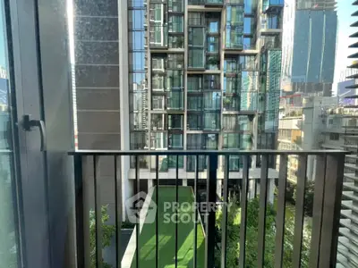 Modern urban balcony with stunning cityscape view and lush green surroundings.