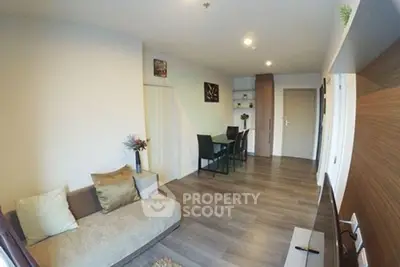 Modern living room with stylish decor and open layout, featuring a cozy sofa and dining area.