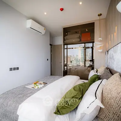 Luxurious modern bedroom with city view, elegant decor, and cozy bedding in high-rise apartment.