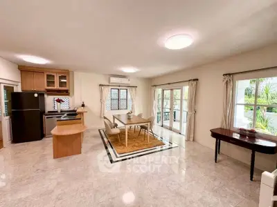 Spacious open-plan living area with modern kitchen and dining space, featuring large windows and natural light.