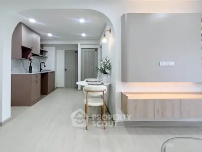 Modern open-layout kitchen with sleek cabinetry and elegant dining area in a stylish apartment.