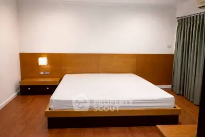 Spacious modern bedroom with wooden flooring and minimalist design