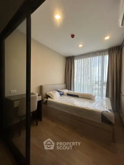 Modern bedroom with large window and natural light, featuring a comfortable bed and stylish decor.