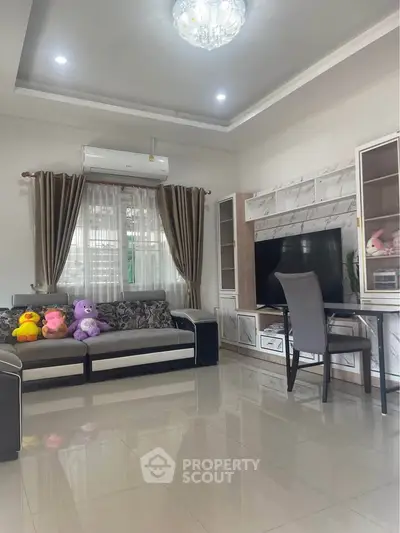 Spacious living room with modern decor and large TV, perfect for family gatherings.