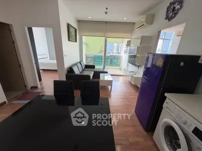 Modern apartment interior with open living room, kitchen, and balcony view.