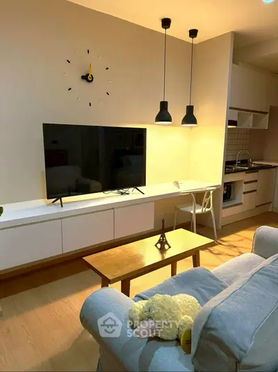Modern living room with stylish furniture and open kitchen layout, featuring a cozy ambiance and elegant lighting.