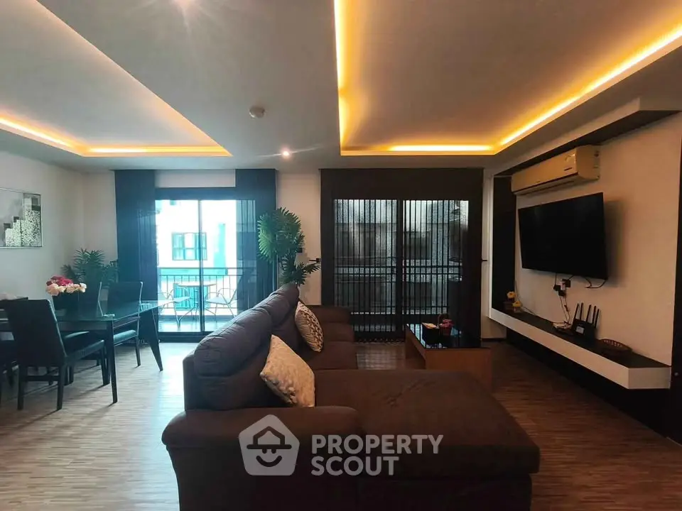 Spacious modern living room with stylish lighting and large windows in a luxury apartment.