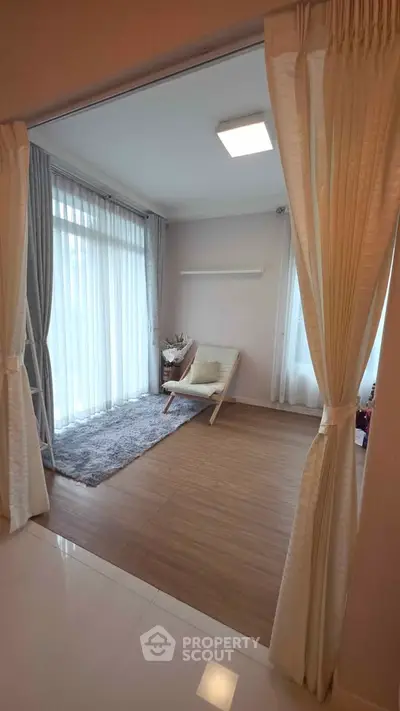 Cozy and inviting small living area with natural light and elegant curtains.