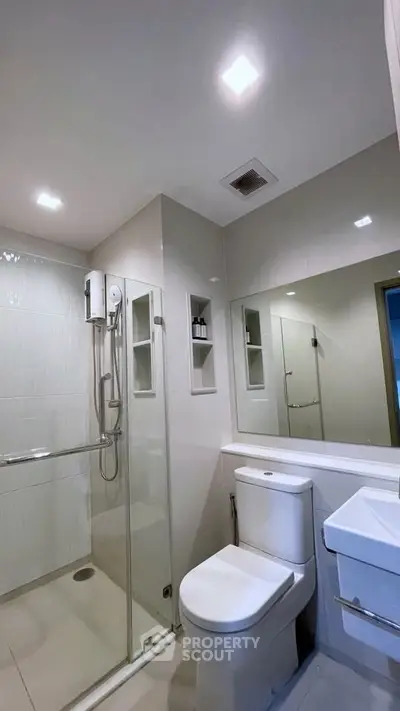 Modern bathroom with glass shower enclosure and sleek fixtures