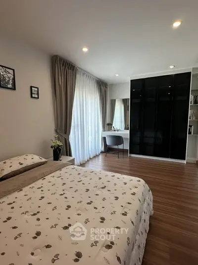 Spacious bedroom with elegant decor and large window for natural light