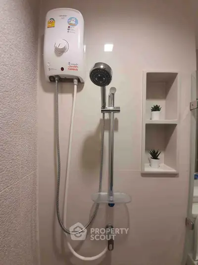 Modern bathroom with sleek shower and water heater, featuring minimalist design and built-in shelves.