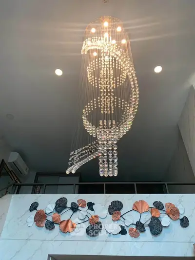 Luxurious modern chandelier in elegant interior with artistic wall decor