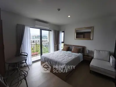 Modern bedroom with balcony view in a stylish apartment, featuring cozy bed and elegant decor.