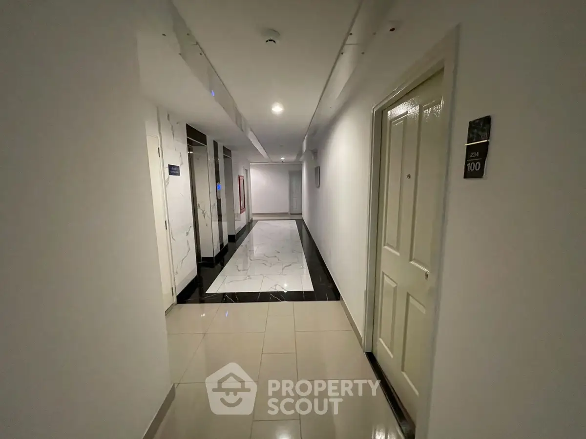 Modern apartment corridor with sleek tile flooring and elegant lighting