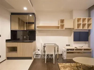 Modern minimalist kitchen with sleek cabinetry and dining area in stylish apartment.
