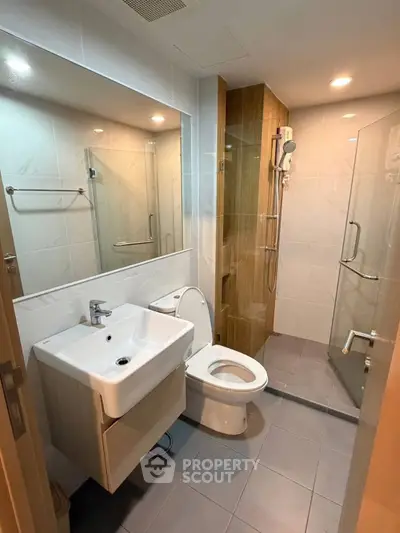Modern bathroom with glass shower and sleek fixtures in a contemporary apartment.