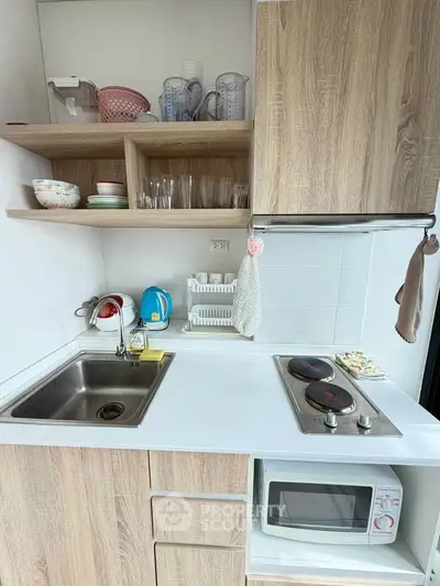 Compact modern kitchen with wooden cabinets and electric stove