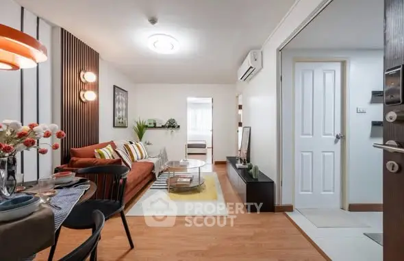 Modern living room with stylish decor and open layout leading to a cozy bedroom.