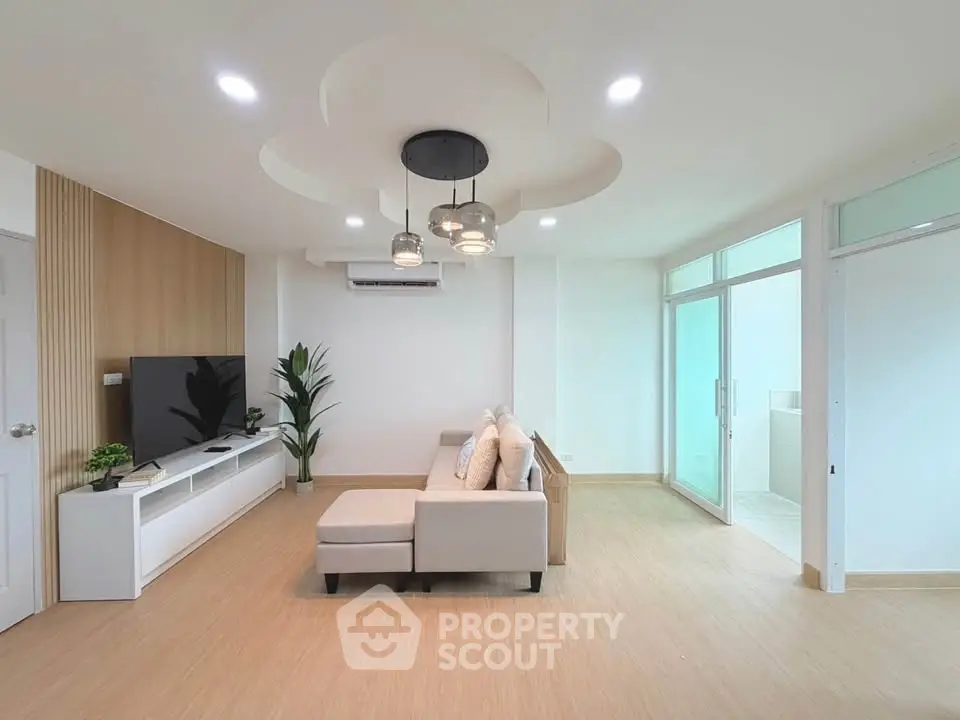 Modern living room with stylish ceiling lights and cozy sofa in a bright, open space.