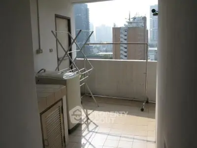 Spacious balcony with city view and laundry area in urban apartment