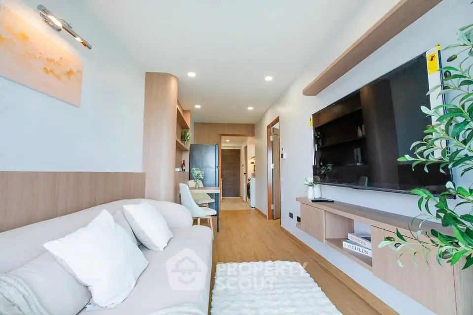 Modern living room with sleek design and large TV, featuring cozy seating and stylish decor.