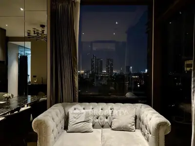 Luxurious living room with plush sofa and stunning city night view.