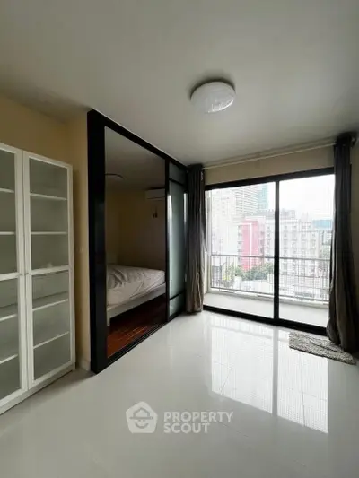 Modern bedroom with glass partition and city view balcony in high-rise apartment