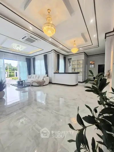 Luxurious living room with elegant chandeliers and marble flooring, featuring a spacious open layout and modern decor.