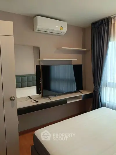 Modern bedroom with sleek TV setup and air conditioning, featuring elegant curtains and stylish decor.