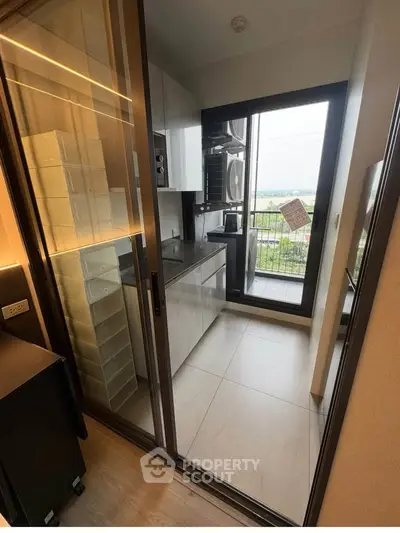 Modern compact kitchen with balcony view and sleek appliances
