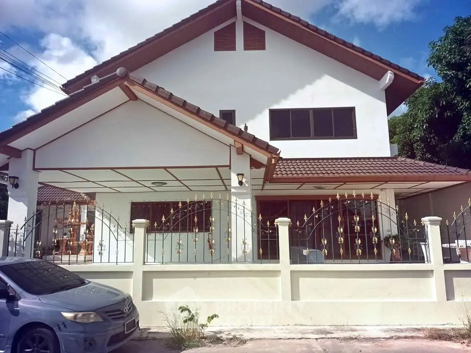 Charming two-story house with gated entrance and tiled roof, perfect for family living.