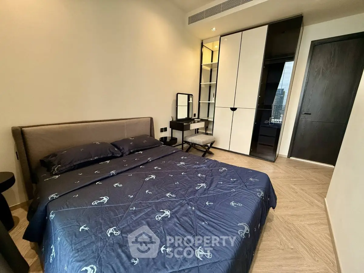 Modern bedroom with stylish decor and city view, featuring a comfortable bed and sleek wardrobe.