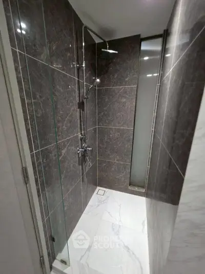 Modern bathroom with sleek shower and marble tiles, perfect for luxury living.