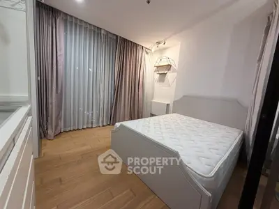 Cozy bedroom with elegant curtains and modern lighting in a stylish apartment.